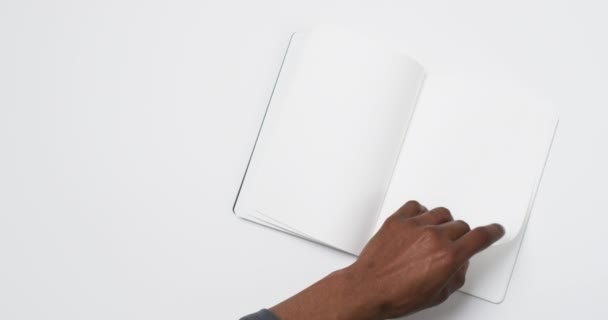 アフリカ系アメリカ人男性が白いページで本を持ち 白い背景のスペースをコピーするビデオ ライティング テクスチャ 素材コンセプト — ストック動画