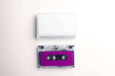 Mor kaset ve beyaz arka planda düzenlenmiş beyaz kutunun genel görünümü. Müzik, ses, dinleme, eğlence ve nostalji konsepti.