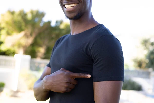 Smiling African American Man Black Shirt Pointing Sleeve Copy Space — Stock Photo, Image