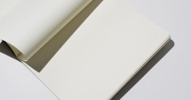 Beyaz boş sayfaları olan bir kitap videosu ve beyaz arkaplan üzerine kopyalama alanı. Kitap, edebiyat, kağıt, yazı, doku ve materyal kavramı.