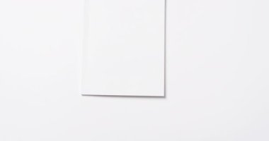 Beyaz boş sayfaları olan bir kitap videosu ve beyaz arkaplanda asılı duran bir kopya alanı. Kitap, edebiyat, kağıt, yazı, doku ve materyal kavramı.