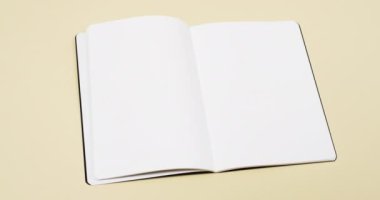 Beyaz boş sayfalı bir kitap videosu ve sarı arkaplandaki boşluğu kopyala. Kitap, edebiyat, kağıt, yazı, doku ve materyal kavramı.