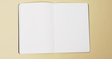 Beyaz boş sayfalı bir kitap videosu ve sarı arkaplandaki boşluğu kopyala. Kitap, edebiyat, kağıt, yazı, doku ve materyal kavramı.