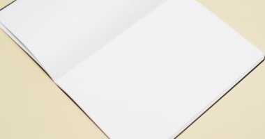 Beyaz boş sayfalı bir kitap videosu ve sarı arkaplandaki boşluğu kopyala. Kitap, edebiyat, kağıt, yazı, doku ve materyal kavramı.