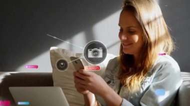 Akıllı telefon kullanan Kafkasyalı iş kadını üzerindeki simgelerle bağlantı ağının animasyonu. Küresel iş, sosyal medya, dijital arayüz ve dijital olarak oluşturulan veri işleme kavramı.