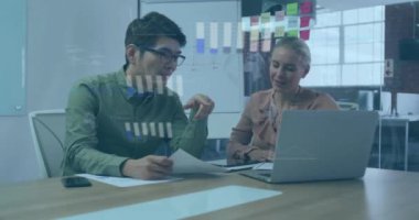 Dizüstü bilgisayarla ilgili raporları tartışan çeşitli iş arkadaşları üzerinde grafiklerin ve kürelerin animasyonu. Dijital bileşik, çoklu pozlama, iş, küreselleşme, planlama, takım çalışması ve teknoloji kavramı.