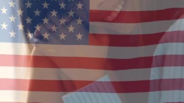 Amerika 'nın ulusal bayrağının güzel, melez bir kadının yakından dalgalanması. Dijital kompozit, çoklu pozlama, portre, özgürlük, hükümet ve vatanseverlik kavramı.