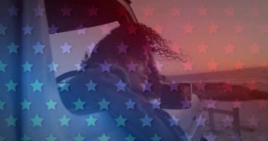 Mavi ve kırmızı yıldızların animasyonu arabada oturan melez kadının üzerinde. Vatanseverlik ve kutlama konsepti dijital olarak oluşturulmuş video.