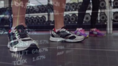 Spor salonunda egzersiz yapan insanlarla ilgili finansal veri işleme animasyonu. Küresel spor, iş, bilgisayar, veri işleme ve bağlantılar konsepti dijital olarak oluşturulmuş video.