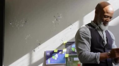 Afro-Amerikan bir adamın ofisteki akıllı telefonuyla daire çizerek profil ikonu canlandırması. Dijital bileşik, çoklu pozlama, iş, şekil, soyut ve teknoloji kavramı.