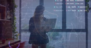 Bilgisayarı kullanan beyaz bir kadın üzerinde grafik ve takas panosuyla kalkan simgesinde kilit animasyonu. Dijital bileşik, siber güvenlik, koruma, yatırım, ticaret, rapor, ofis, teknoloji.