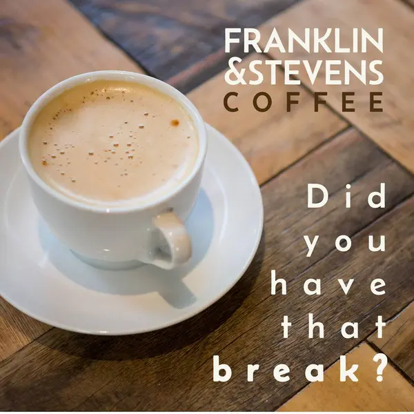 Composition of franklin and stevens coffee text over cup of coffee on wooden table. Food, drink, coffee and communication concept digitally generated image.