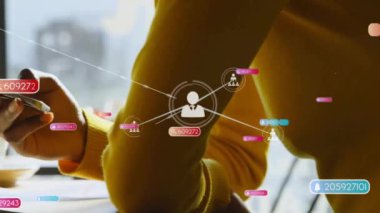 Akıllı telefon kullanan Afro-Amerikan kadın üzerindeki simgelerle bağlantı ağının animasyonu. Küresel iş, sosyal medya, dijital arayüz ve dijital olarak oluşturulan veri işleme kavramı.
