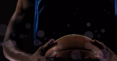 Siyah arka planda ışık lekeleri ve topları olan Afrikalı Ameerikalı basketbolcu animasyonu. Spor, rekabet ve hareket kavramı dijital olarak oluşturulmuş imaj.