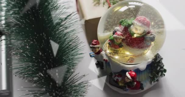 Animation Von Schnee Der Über Die Weihnachtsschneekugel Und Dekorationen Fällt — Stockvideo