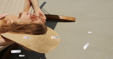 Sahilde güneşlenen beyaz kadınlara karşı yüzen sosyal medya simgelerinin canlandırılması. Sosyal medya ağı ve tatil kavramı