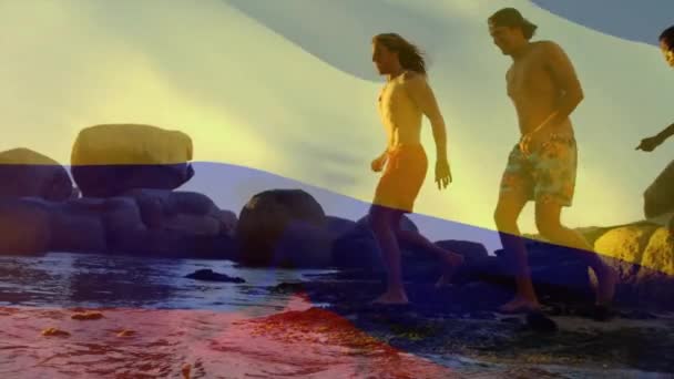 日当たりの良いビーチで走っている多様な友人に対するコロンビアの旗のアニメーション コロンビア トータルネス 愛国心 デジタル生成されたビデオ — ストック動画