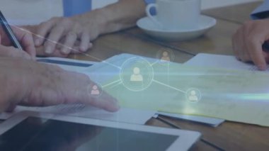 Kıdemli çift formlarını dolduran kesilen insan elleri üzerine bağlı ikonların animasyonu. Dijital bileşik, çoklu pozlama, iş, emeklilik, sigorta ve iletişim konsepti.