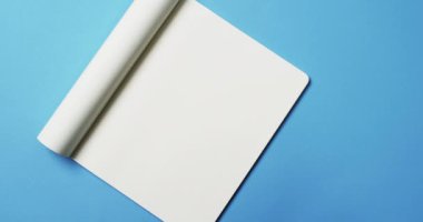 Beyaz boş sayfalı kitap videosu ve mavi arkaplan üzerine kopya alanı. Kitap, edebiyat, kağıt, yazı, doku ve materyal kavramı.