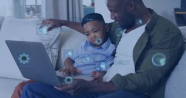 Evde dizüstü bilgisayar kullanarak mutlu bir Afrikalı Amerikalı baba ve oğlunun veri işleme animasyonu. Veri, dijital arayüz, iletişim, yaşam tarzı, aile ve birliktelik, dijital olarak oluşturulmuş video.