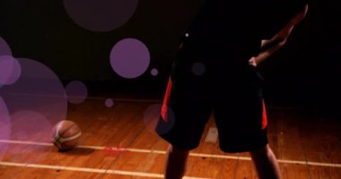 Kafkas basketbolcunun top attığı ve siyah arka planda ışık lekeleri oluşturduğu animasyon. Spor, rekabet ve hareket kavramı dijital olarak oluşturulmuş imaj.