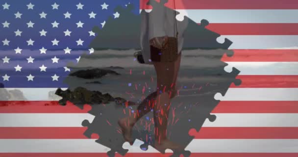 Animacja Flagi Usa Kawałkami Układanki Nad Białą Kobietą Spacerującą Plaży — Wideo stockowe