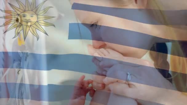 Animação Bandeira Uruguaia Sobre Mãe Caucasiana Beijando Pés Bebê Uruguai — Vídeo de Stock
