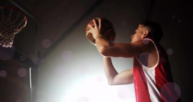 Kafkas basketbolcunun top attığı ve siyah arka planda ışık lekeleri oluşturduğu animasyon. Spor, rekabet ve hareket kavramı dijital olarak oluşturulmuş imaj.