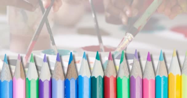 クラスでブラシや塗料を使用した多様な子供たちの手の上に色鉛筆のアニメーション アート 創造性 幼少期 デジタル生成されたビデオ — ストック動画
