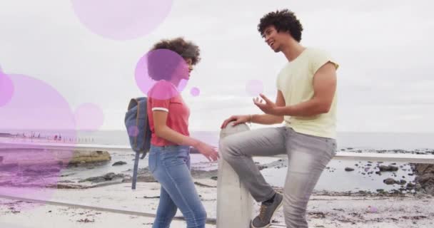 ビーチの遊歩道で話している幸せなカップルの紫色のスポットのアニメーション ロマンス 自由時間 デジタル生成されたビデオ — ストック動画