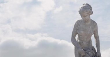 Mavi gökyüzü ve bulutların üzerindeki gri kadın heykelinin animasyonu, boşluğu kopyala. Soyut arkaplan, sanat ve heykel kavramı, dijital olarak oluşturulmuş video.