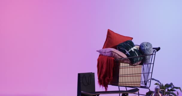 购物车上满是家庭装饰物品 如垫子和扔毛毯 还有复制空间 色彩斑斓的背景和布局暗示了一个与室内设计元素购物相关的概念 — 图库视频影像