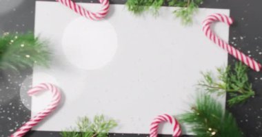 Noel ağacı dalları, lolipoplar ve boş kağıt parçalarının üzerinde beyaz dairelerin canlandırılması. Noel, gelenek, kış ve kutlama konsepti dijital olarak oluşturulmuş video.