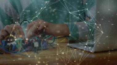 Laptop kullanan, odaklanmış beyaz bir çocuk üzerinden bağlı çemberler ağının animasyonu. Teknoloji, bağlantı, iletişim, bilgisayar, çocukluk ve ifade kavramı dijital olarak oluşturulmuş video.
