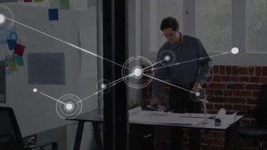 Ofiste çalışan Kafkasyalı işadamı üzerinden bağlantı ağının animasyonu. Küresel iş, iletişim, bağlantılar ve dijital arayüz konsepti dijital olarak oluşturulmuş video.