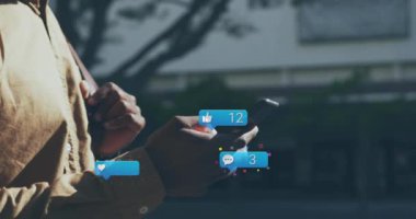 Sosyal medya simgelerinin animasyonu ve akıllı telefon kullanan Afro-Amerikan erkeğinin verileri. Küresel finans, iş, bağlantılar, hesaplama ve veri işleme kavramı dijital olarak oluşturulmuş video.