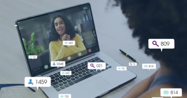 在笔记本电脑视频通话中 通过非洲裔美国妇女对社交媒体图标和数据进行动画制作 全球金融 计算和数据处理概念 — 图库视频影像
