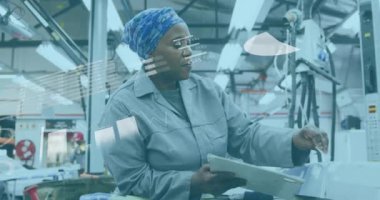 Fabrikada çalışan Afrikalı Amerikalı bir kadının veri işleme animasyonu. Üretim, işletme, bağlantı, veri, dijital arayüz ve iletişim, dijital olarak oluşturulmuş video.