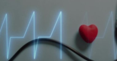 Steteskopa karşı kalp atış hızı montiorunun animasyonu ve gri yüzeyde kırmızı kalp. Tıbbi sağlık ve araştırma teknolojisi kavramı