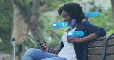 Akıllı telefon kullanan Afrikalı Amerikalı kadınların sosyal medya simgelerinin ve verilerinin animasyonu. Küresel finans, iş, bağlantılar, hesaplama ve veri işleme kavramı dijital olarak oluşturulmuş video.