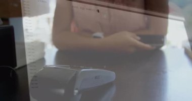 Akıllı telefondan ödeme yapan melez bir kadının veri işleme animasyonu. Küresel irtibatsız ödeme, bağlantılar, bulut hesaplama ve veri işleme kavramı dijital olarak oluşturulmuş video.