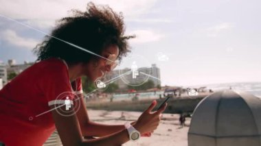 Deniz yoluyla akıllı telefon kullanan melez kadınların üzerindeki ikonlarla olan bağlantıların animasyonu. Küresel seyahat, tatil, bağlantılar, hesaplama ve veri işleme kavramı dijital olarak oluşturulmuş video.
