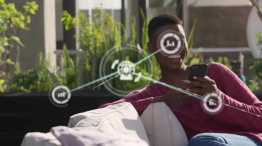 Akıllı telefon kullanan Afro-Amerikan kadın üzerindeki simgelerle bağlantı ağının animasyonu. Dijital olarak oluşturulmuş küresel bağlantılar, hesaplama ve veri işleme kavramı.
