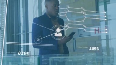 Akıllı telefon kullanarak Afro-Amerikan iş adamının bağlantılarının ve veri işleme programının animasyonu. Küresel iş, bağlantılar, iletişim ve dijital arayüz kavramı dijital olarak oluşturulmuş video.