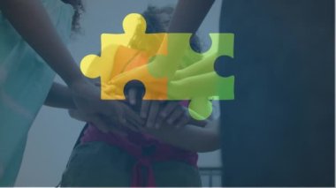 Çeşitli çocukların el ele tutuşmalarının düşük açılı görüntüsüne bağlı yapboz parçalarının animasyonu. Dijital bileşik, çoklu pozlama, çocukluk, birliktelik, birlik, otizm farkındalık kavramı.