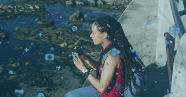 Kamerayla fotoğraf çeken bir kadının üzerindeki ampul ikonlarıyla bağlantı ağının görüntüsü. Dijital arayüz küresel ağ bağlantısı ve dijital olarak oluşturulan iletişim konsepti.