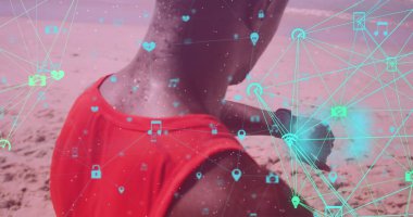 Sahilde ukalalık yapan Afro-Amerikan formda bir adama karşı dönen dijital ikon küreleri. Spor, spor ve teknoloji konsepti