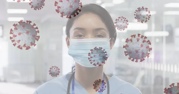 Image of floating covid-19 cells with scientist looking at camera wearing face masks. Healthcare and protection during coronavirus covid 19 pandemic, digitally generated image