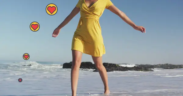 ビーチで踊る女性に対する心臓のデジタルアイコンのイメージ デジタルインターフェース ソーシャルメディア グローバルテクノロジーコンセプトをデジタルで生成 — ストック写真