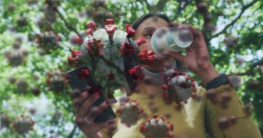 Parktaki kadının yüz maskesi takıp kahve içen akıllı telefon kullanan 19 hücresinin görüntüsü. küresel covid 19 salgın hastalık, sağlık ve tıp konsepti dijital olarak üretilen görüntü.